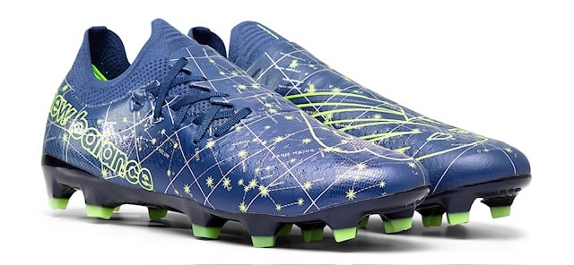 Side view of blue and green New Balance soccer cleats.